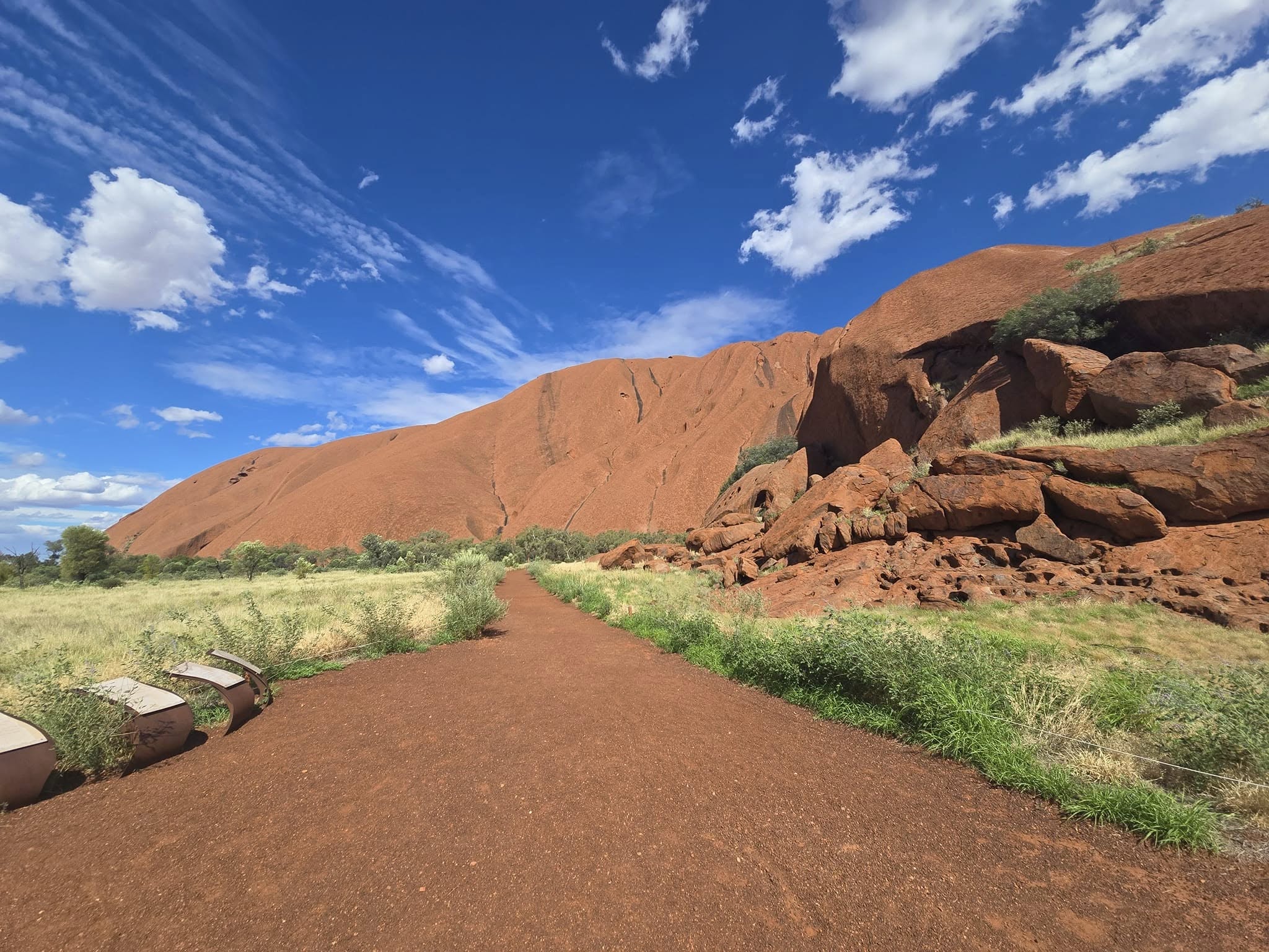Uluru ก้อนหินศักดิ์สิทธิ์กลางทะเลทรายออสเตรเลีย เส้นทางเดินรอบก้อนหิน Uluru ท่ามกลางท้องฟ้าสดใสในออสเตรเลีย